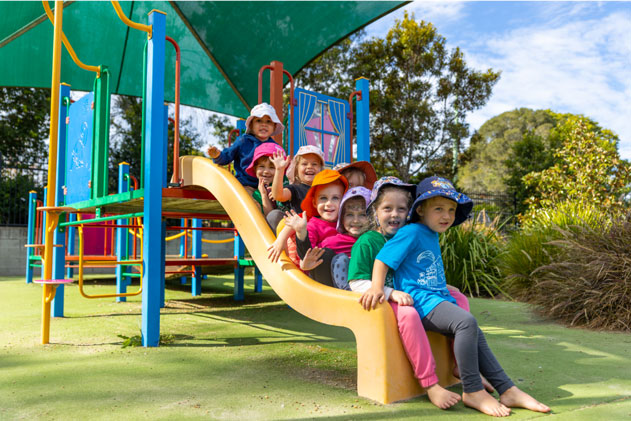 A lovely photo of children playing on the slide at our Early Years Centre in QLD