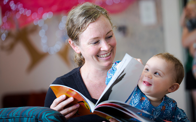 mum with little kid reading a book