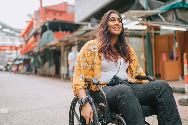 A female wheelchair user navigating an urban environment outdoors