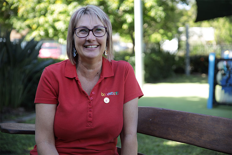 Portrait of a Benevolent staff member wearing a red shirt outside