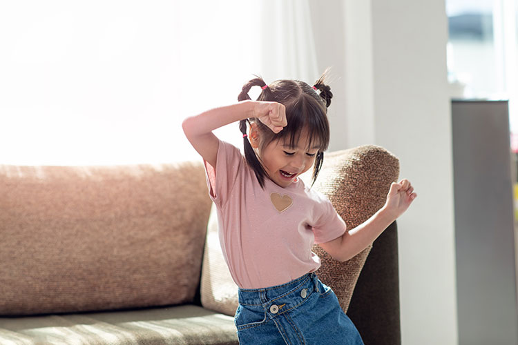 A young girl dancing in her living room
