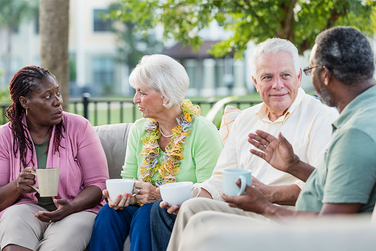 A group of older people talking together on their balcony