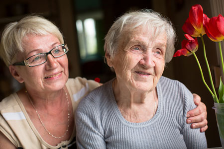 A photo of an elderly woman smiling with her friend