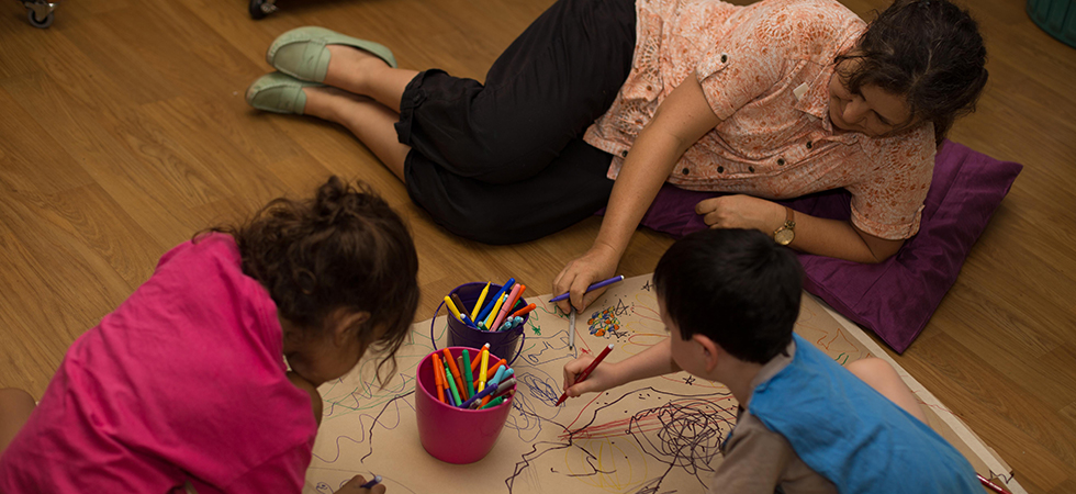 The Benevolent Society staff and children drawing in the floor