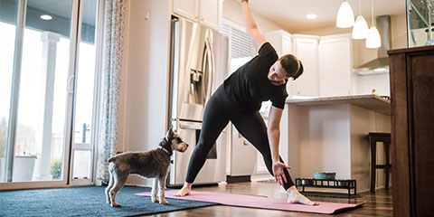 A mature aged woman performing exercise stretches at home