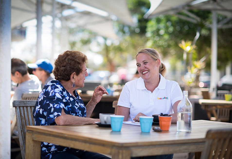An aged care client and her support worker enjoying a coffee in the local cafe